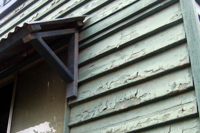 The flood-damaged weatherboards are covered in lead paint.