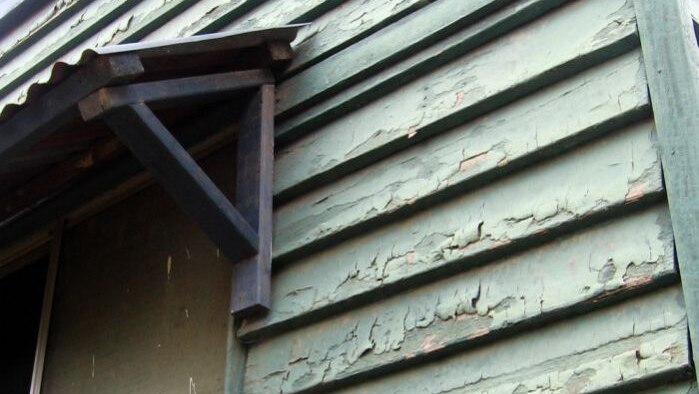 The flood-damaged weatherboards are covered in lead paint.