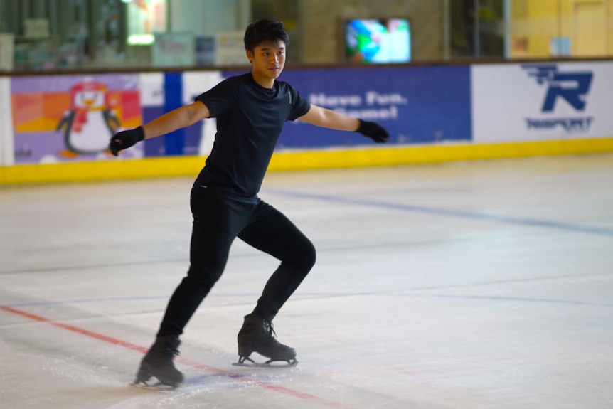 Calvin Pratama figure skating with his arms out by his sides.