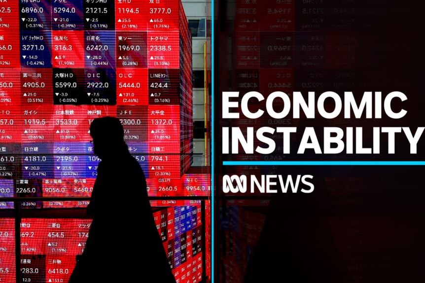Economic Instability: Silhoueted person walks in front of stock board