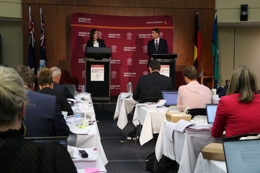 Annastacia Palaszczuk and Cameron Dick stand on a stage.