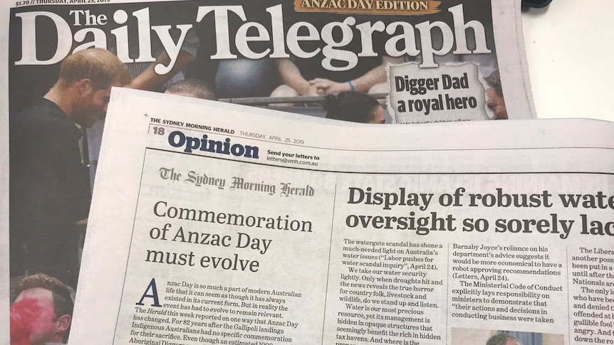 A Sydney Morning Herald page is sitting on top of the front cover of the Daily Telegraph.