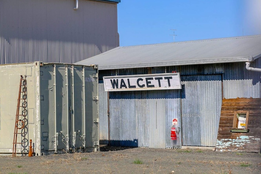 A Walgett sign hanging on a corrugated metal building.