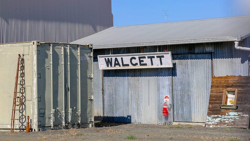 A Walgett sign hanging on a corrugated metal building.