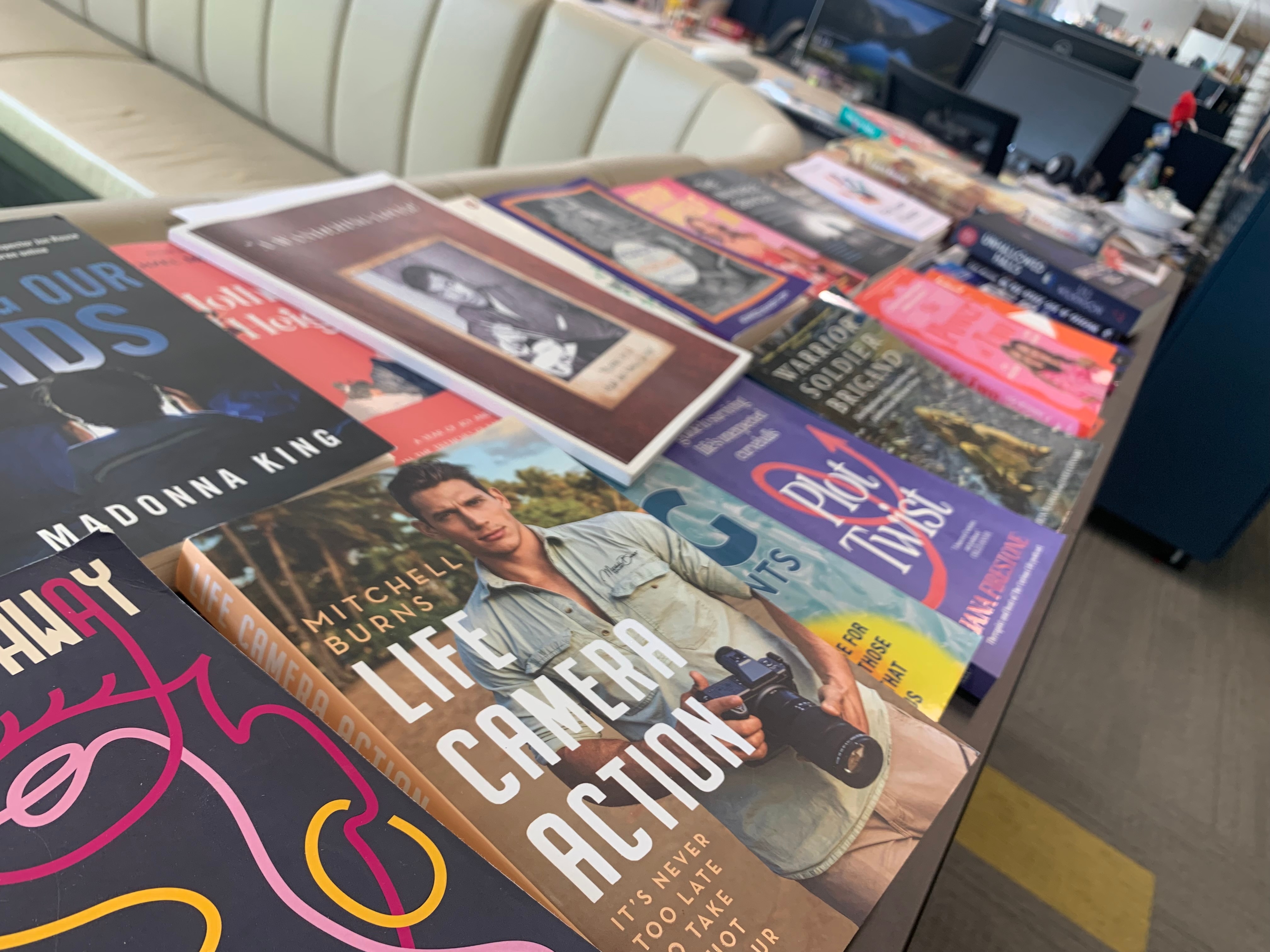 A smattering of books lies along the top of a cabinet in an office