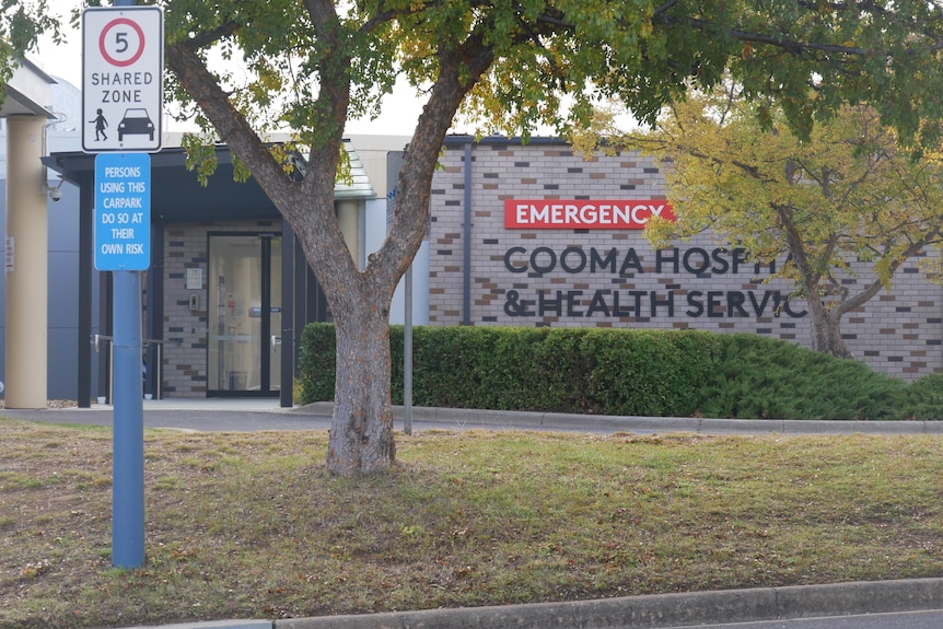 a sign of the cooma hospital with a tree in the foreground