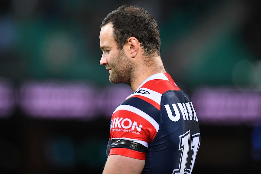 A Sydney Roosters NRL player bows his head during a minute's silence before the match against Newcastle.