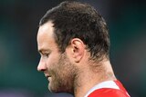 A Sydney Roosters NRL player bows his head during a minute's silence before the match against Newcastle.