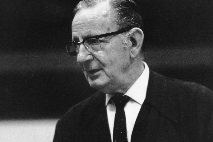 A black and white photograph of Australian conductor Sir Bernard Heinze standing with hands clasped.