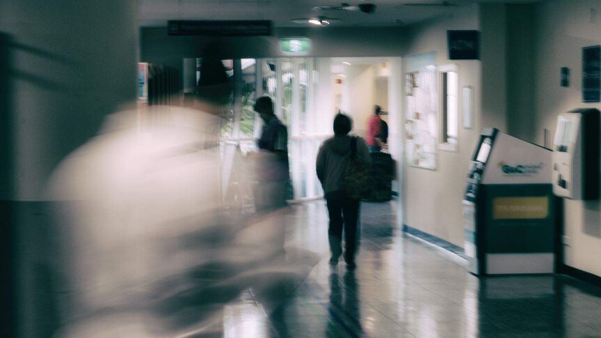 blurred and silhouette figures in a hospital foyer