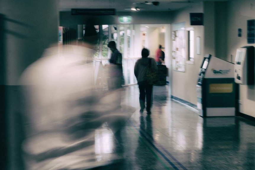 blurred and silhouette figures in a hospital foyer