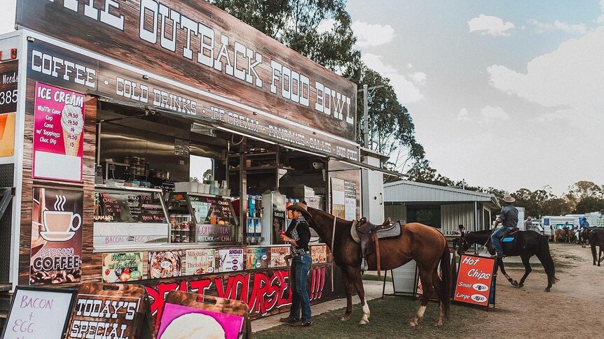 A horse and rider order food from a food stall at a country show.