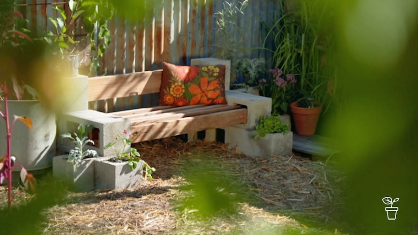 Wooden garden seat with block edges filled with plants