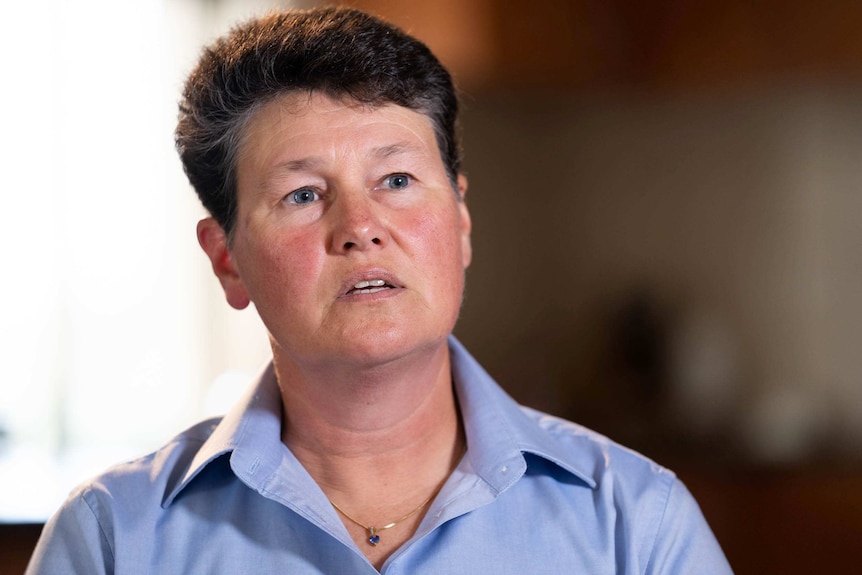 A short-haired woman in a blue shirt.