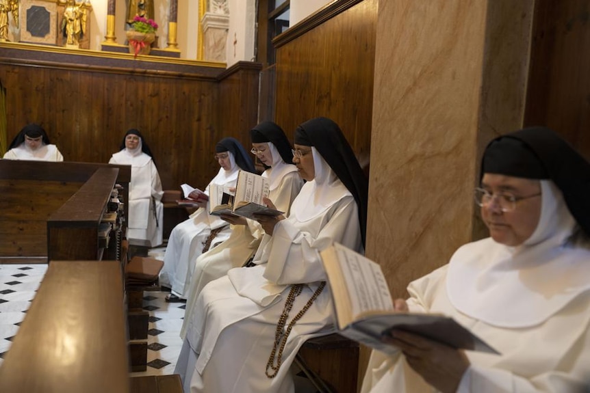 Nuns sit down and read from books 