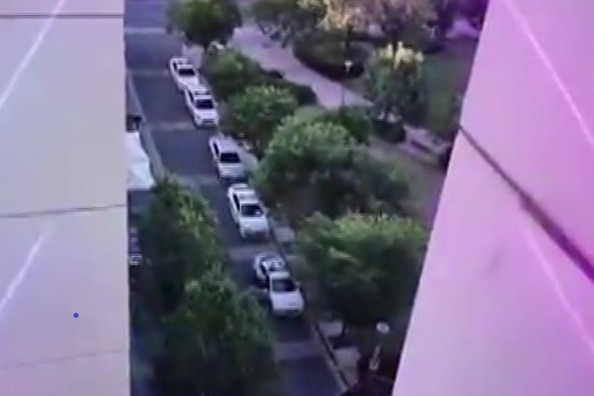 A line of police cars with a silver car in the middle