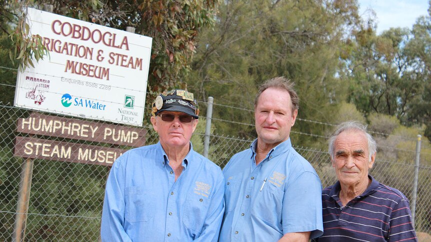 John Reed, Neil Gow and Mervin Dunk stand in front of the Cobdogla museum fence
