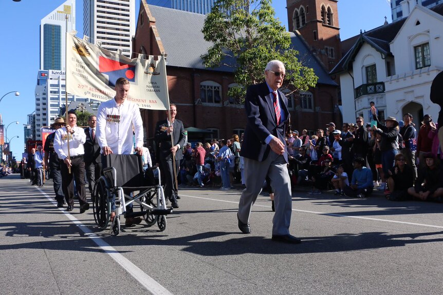 An unidentified man marches ahead of his wheelchair at Perth's Anzac Day parade.