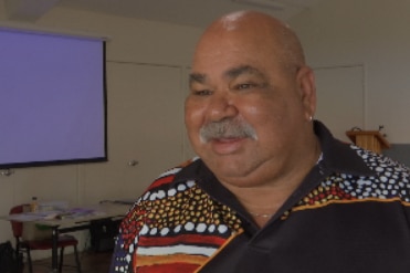 An Indigenous man smiling at the camera