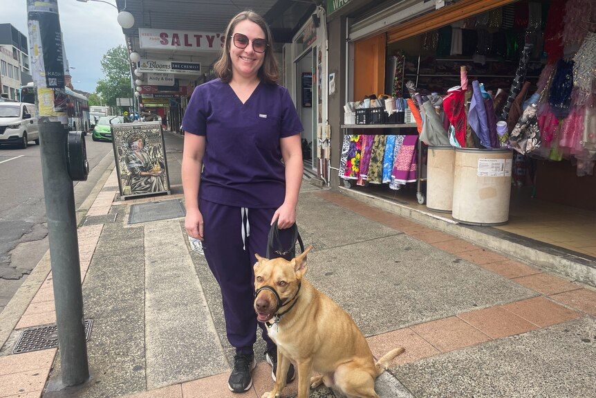 A woman wearing scrubs with a dog
