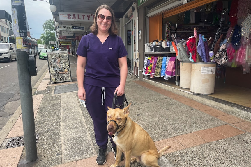 A woman wearing scrubs with a dog