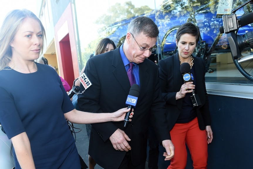 Michael Atkins leaving court surrounded by press pack.