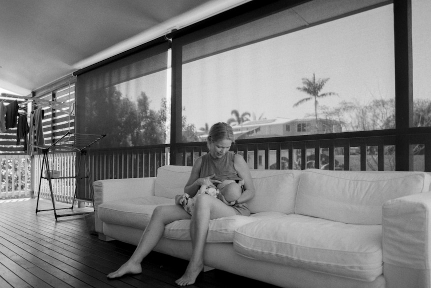 A woman breastfeeding on an outdoor couch 