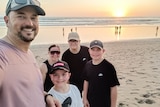 Stephen Clements with his family on a beach.