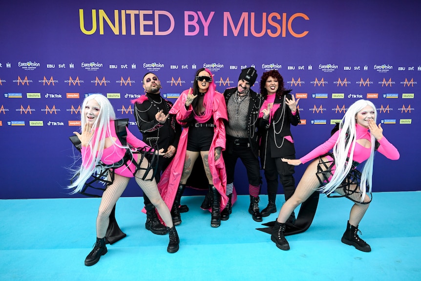 Megara members wearing black and pink plastic outfits