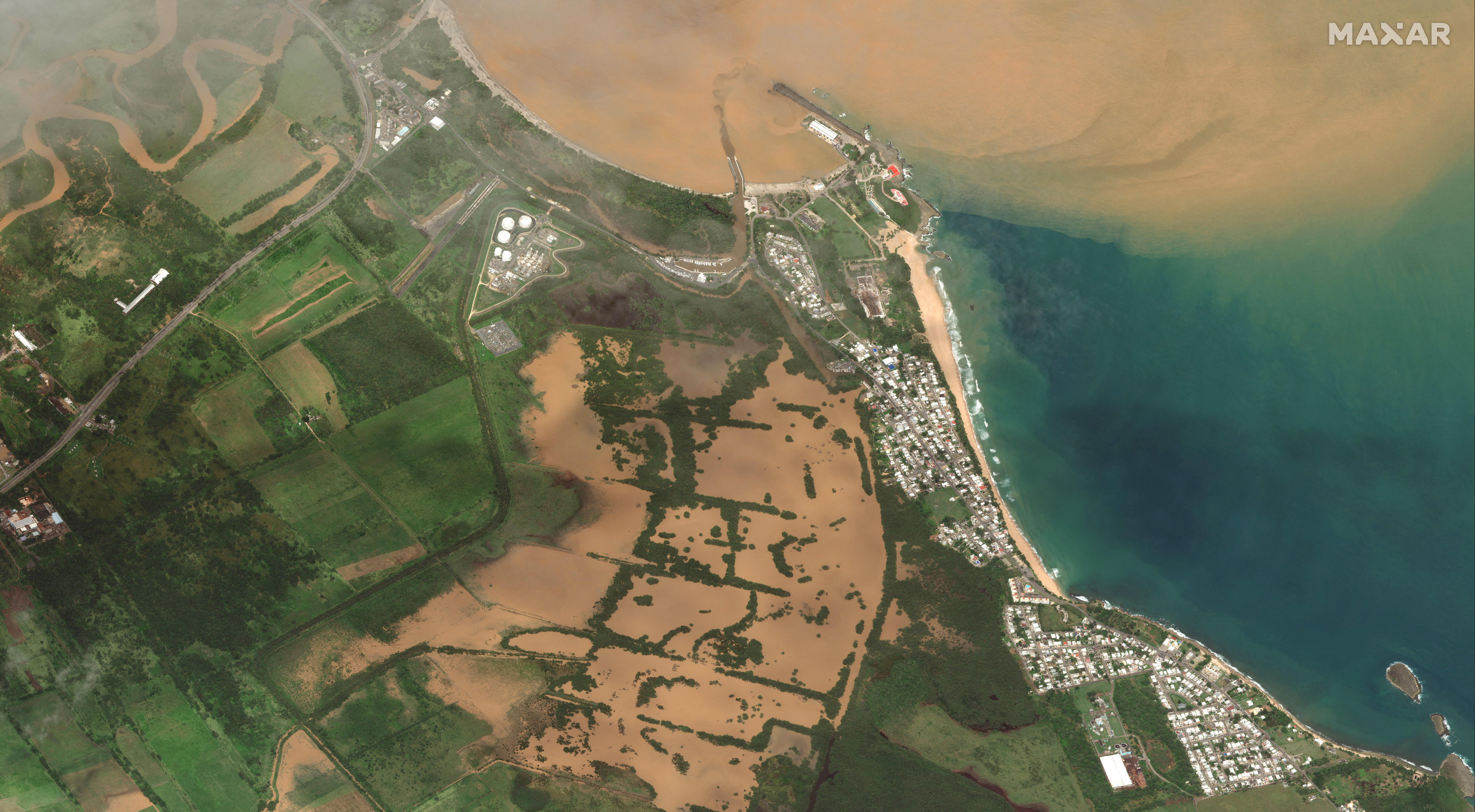 An aerial image of widespread flooding over green fields. 