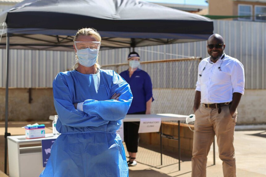 Three medical professionals stand outside at a new testing site
