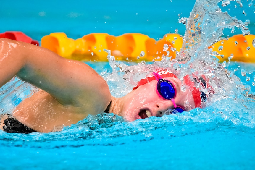 A close-up of Isabella Vincent powering through the water in a freestyle race. You can see her right arm rising out of the pool