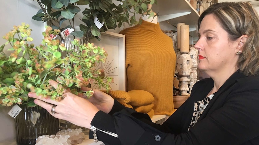 Amber Barnes in Jim and Jane shop arranging plant