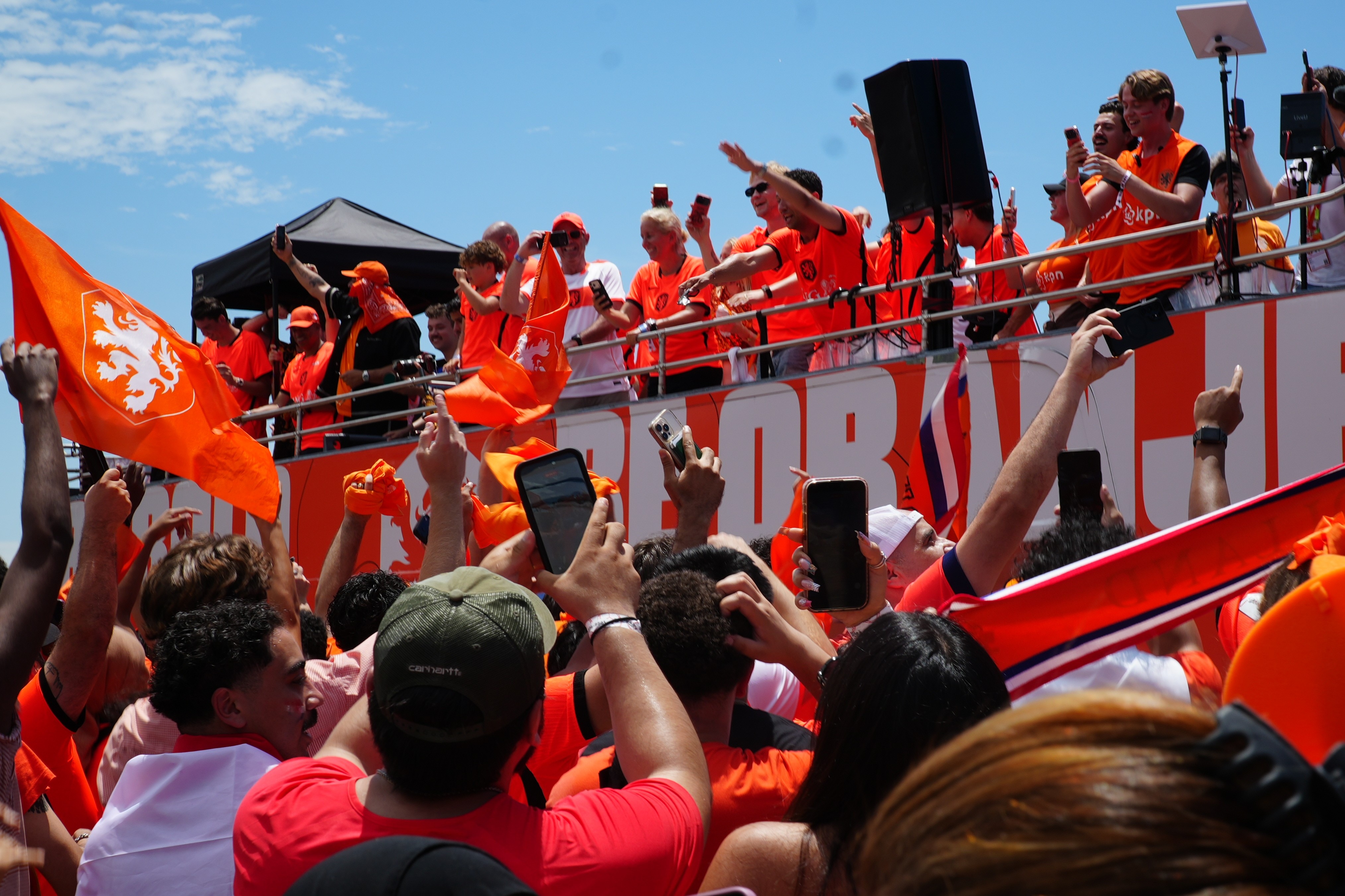 Torcedores vestidos de laranja chegam ao estádio em um ônibus laranja