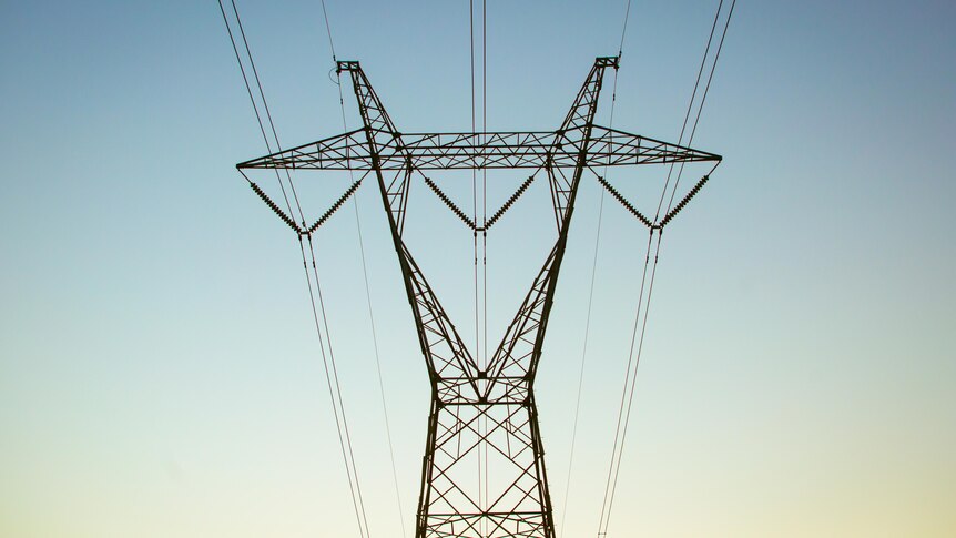 A power pylon against a fading blue sky. 