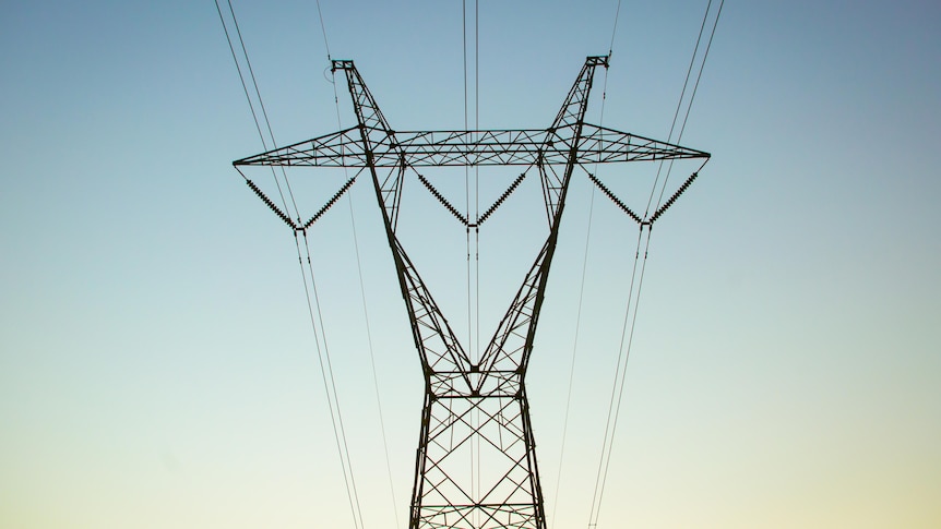 A power pylon against a fading blue sky. 