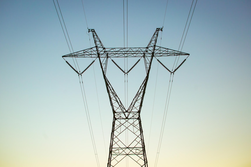 A power pylon against a fading blue sky. 