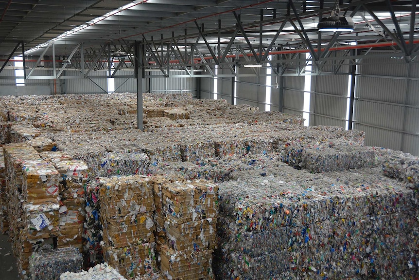 Huge piles of rubbish inside an industrial shed.