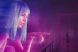 Still image from 2017 film Blade Runner of Ana de Armas' character as a large scale hologram interacting with Ryan Gosling.