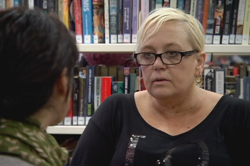 A woman named Leanne speaking to a mentor in a public library.