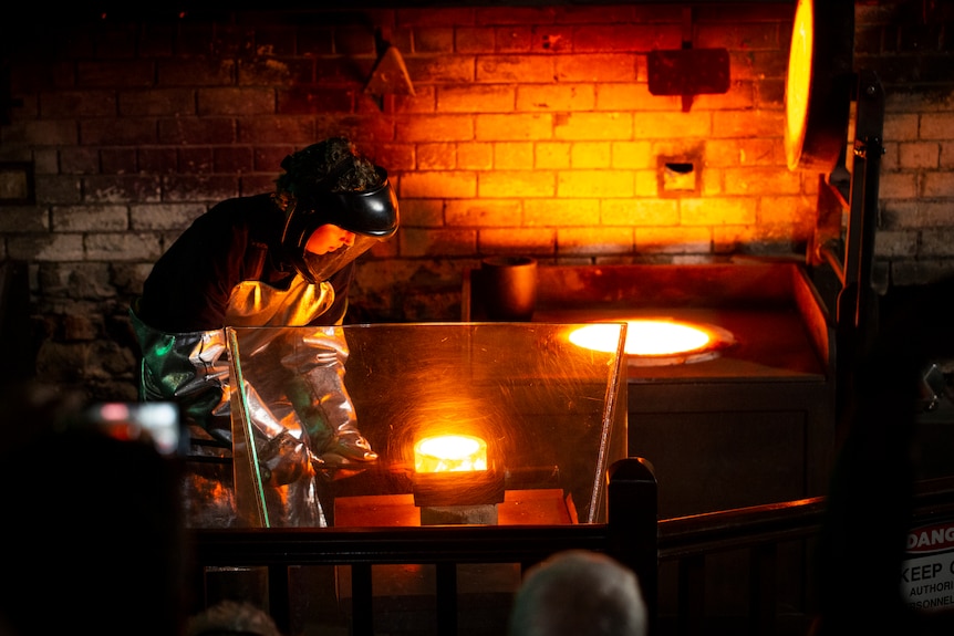 A person pours liquid gold into a container