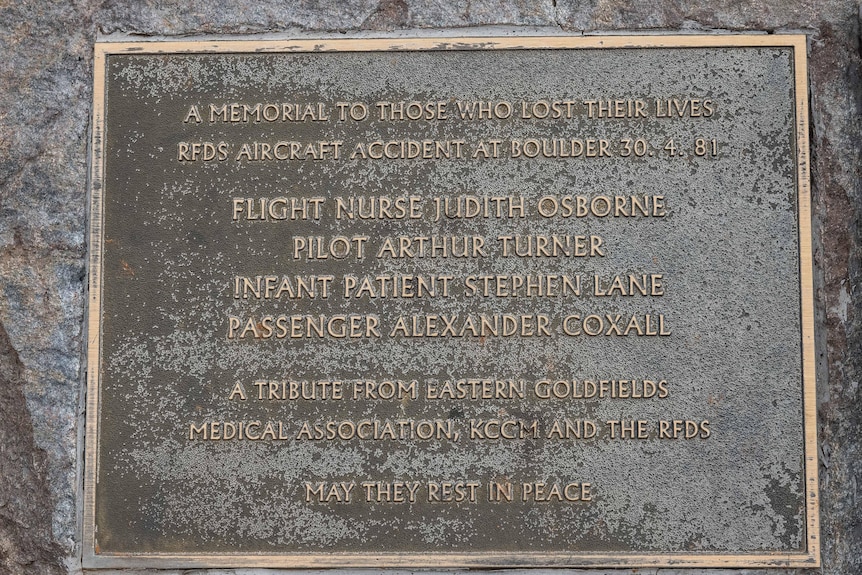 A memorial plaque listing the names of four people who died in a plane crash.  