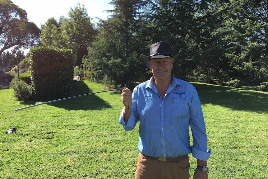 Water diviner Michael O'Neill uses a piece of wire to find water