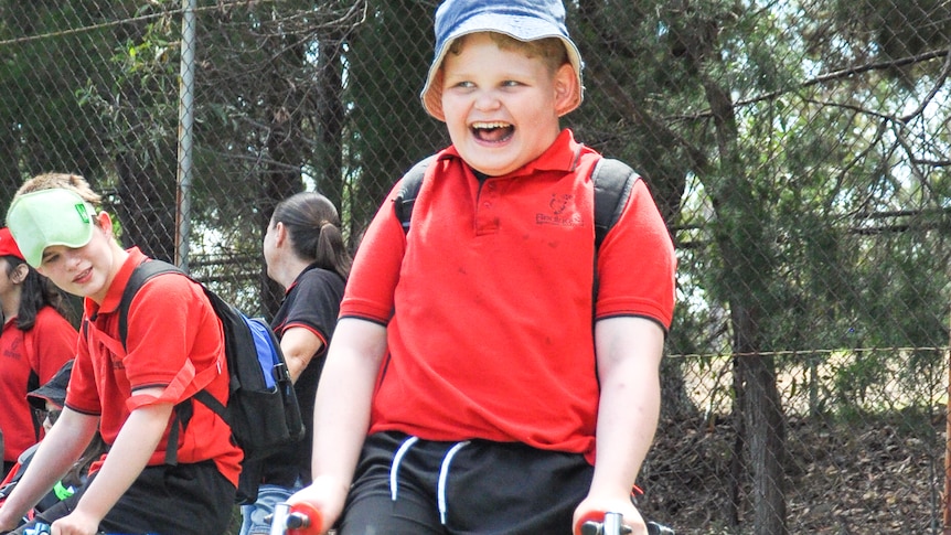 Boy in school hat smiling enthusiastically 