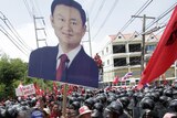 Thaksin supporters break through a cordon of riot policemen