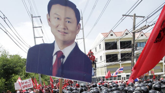 Thaksin supporters break through a cordon of riot policemen