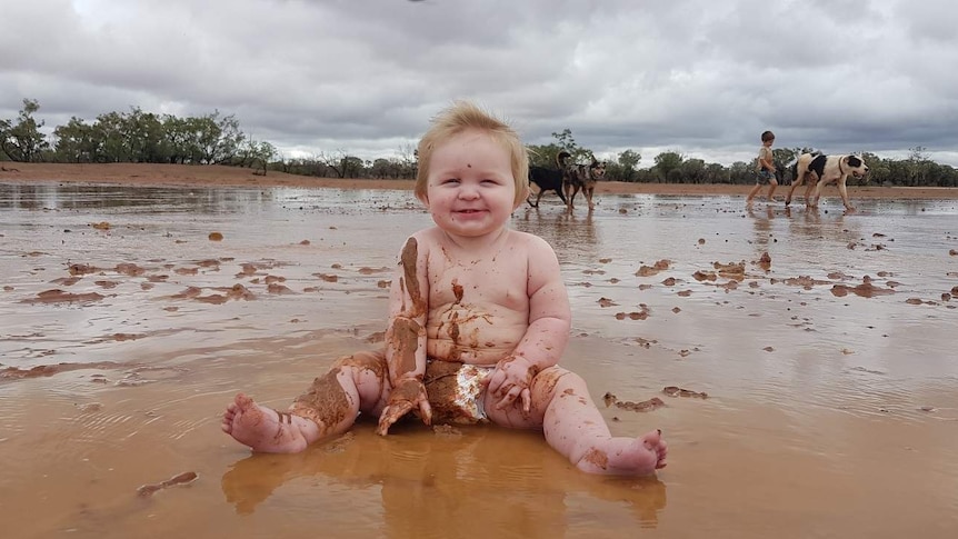 Eight-month-old Riley James Berger plays in the mud.