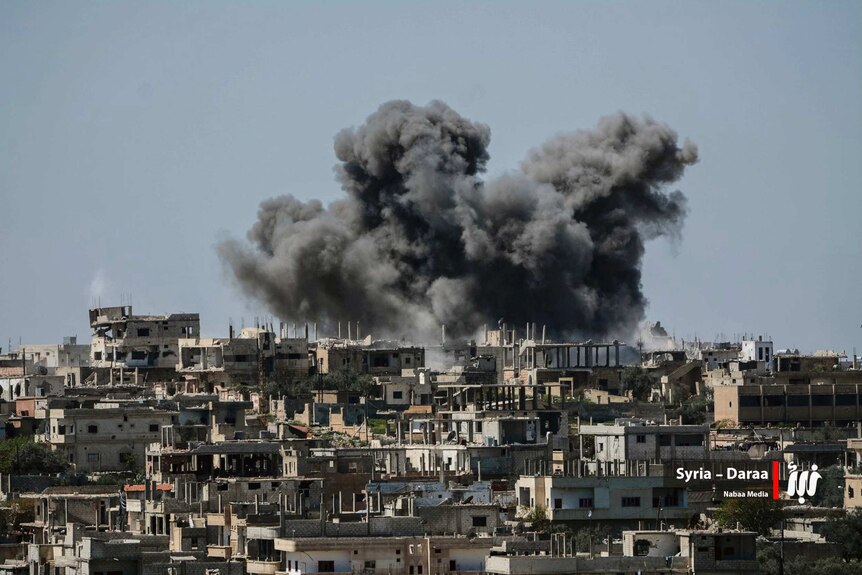 Smoke rising over buildings that were hit by Syrian government forces
