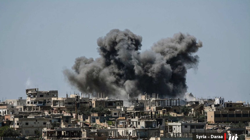 Smoke rising over buildings that were hit by Syrian government forces