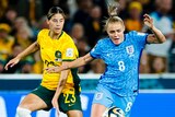 An England player and a Matildas opponent challenge for the ball during the Women's World Cup semifinal.